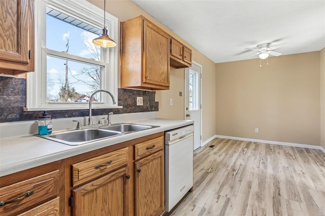 kitchen with decorative backsplash, a healthy amount of sunlight, dishwasher, and a sink