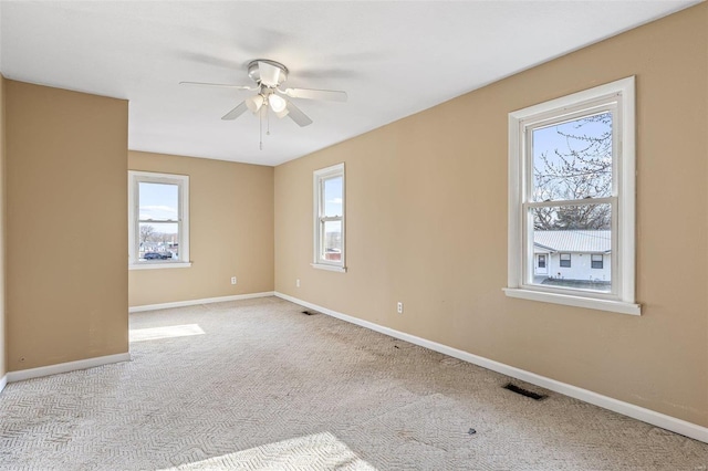 empty room with a ceiling fan, baseboards, visible vents, and carpet flooring