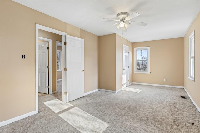 spare room with a ceiling fan, carpet, visible vents, and baseboards