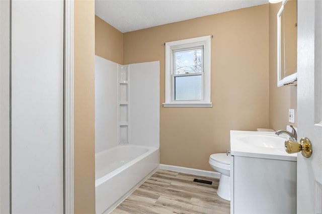 full bathroom featuring baseboards, toilet, wood finished floors, vanity, and washtub / shower combination