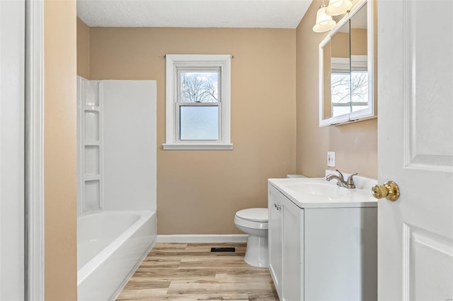 full bathroom with plenty of natural light, vanity, toilet, and wood finished floors