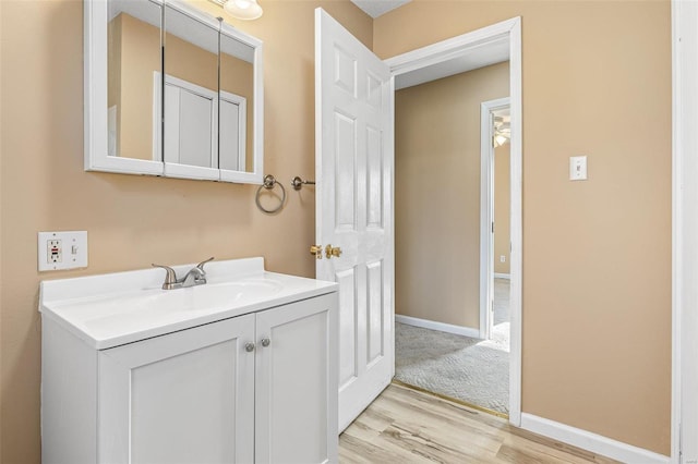 bathroom featuring wood finished floors, vanity, and baseboards