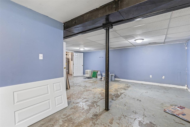 finished basement with a paneled ceiling and baseboards