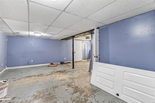 finished below grade area featuring a drop ceiling and baseboards