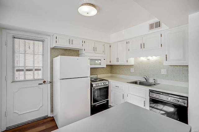 kitchen featuring visible vents, a sink, white appliances, white cabinets, and light countertops