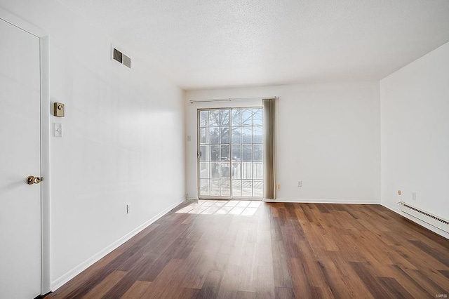 unfurnished room featuring visible vents, a textured ceiling, baseboards, and wood finished floors