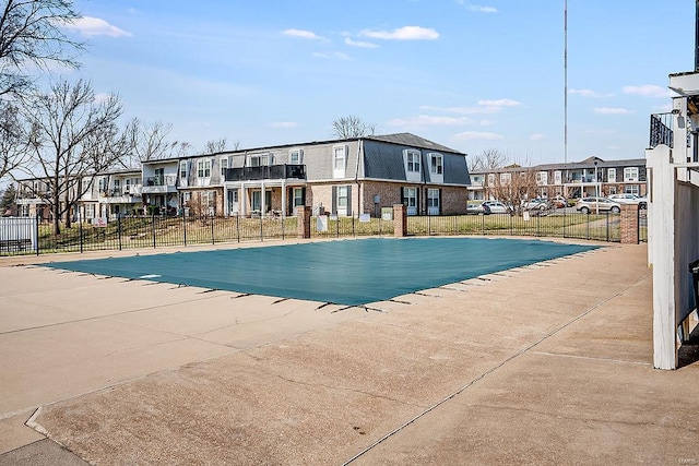 community pool with fence and a residential view