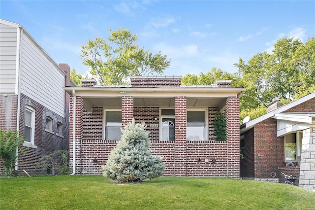 view of front of house featuring brick siding and a front lawn