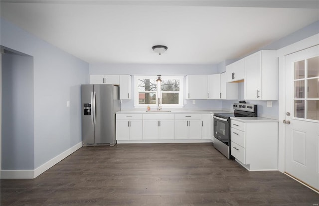 kitchen featuring stainless steel appliances, dark wood-style flooring, a sink, baseboards, and light countertops