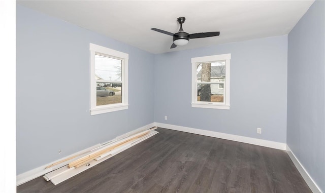 empty room featuring dark wood-style floors, ceiling fan, and baseboards