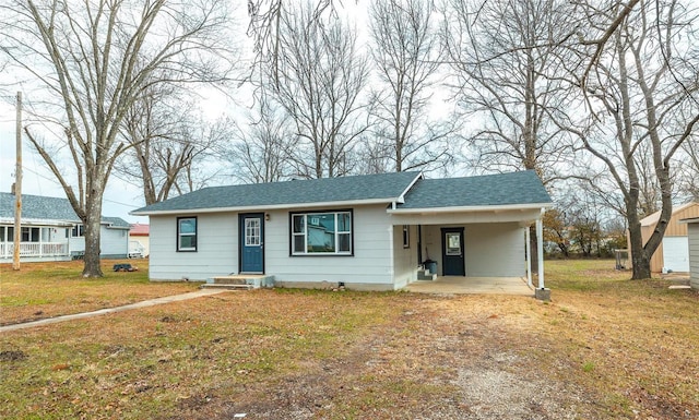 view of front of home with driveway, a front lawn, a carport, and roof with shingles