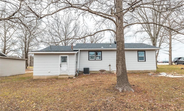 back of property featuring central AC and a shingled roof