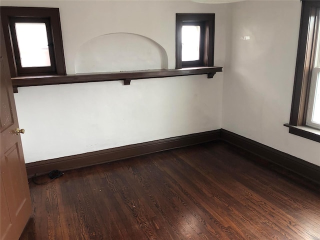 unfurnished room featuring baseboards and wood-type flooring