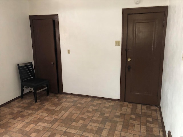 empty room with brick floor and baseboards