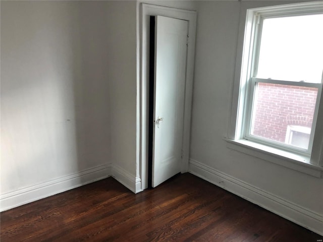 interior space featuring baseboards and dark wood-style floors