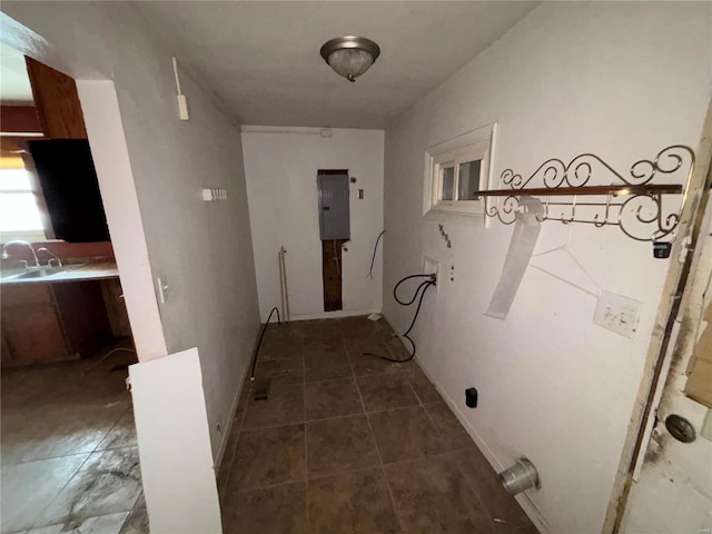 hallway with tile patterned flooring, electric panel, and a sink