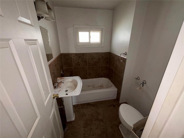 bathroom with toilet, a bathtub, and tile patterned floors