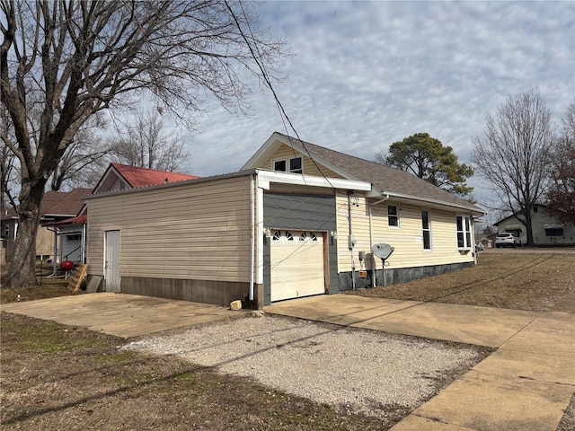 view of property exterior with driveway and an attached garage