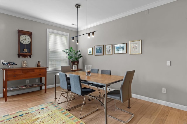 dining area with ornamental molding, light wood-type flooring, and baseboards