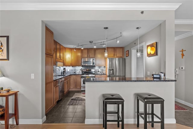 kitchen featuring a breakfast bar area, stainless steel appliances, backsplash, a sink, and a peninsula