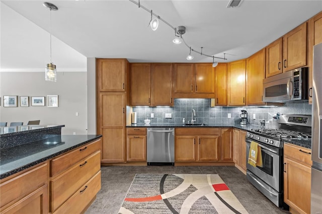 kitchen with appliances with stainless steel finishes, brown cabinetry, a sink, and decorative backsplash