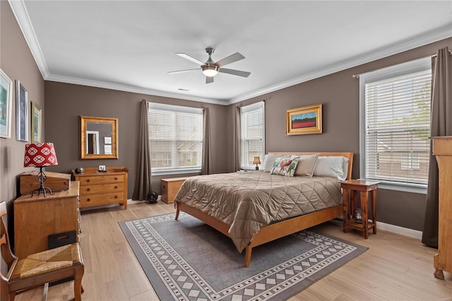 bedroom with light wood-style floors, crown molding, baseboards, and a ceiling fan