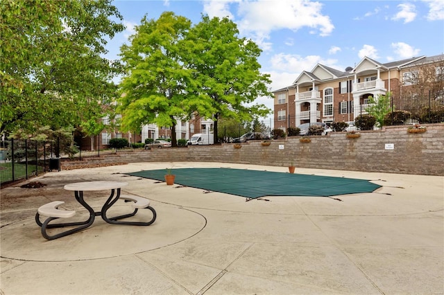 pool with fence and a patio