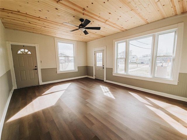 foyer entrance featuring dark wood-style floors, a wainscoted wall, ceiling fan, wooden ceiling, and baseboards