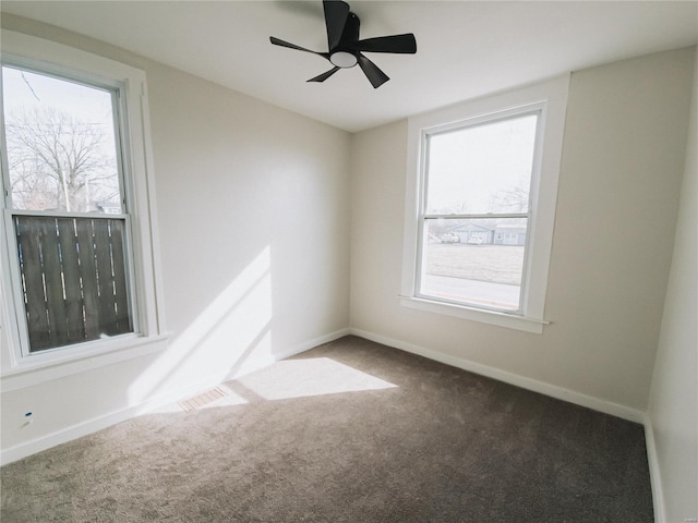 empty room with ceiling fan, visible vents, baseboards, and carpet flooring