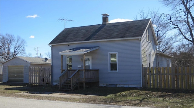 view of front facade with a garage, roof with shingles, fence, and a chimney