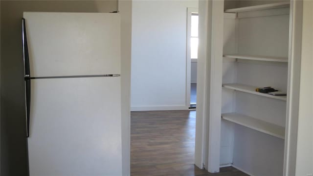 interior space featuring dark wood-type flooring, baseboards, and built in features