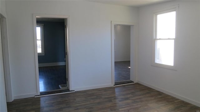 unfurnished room featuring dark wood-style flooring and baseboards