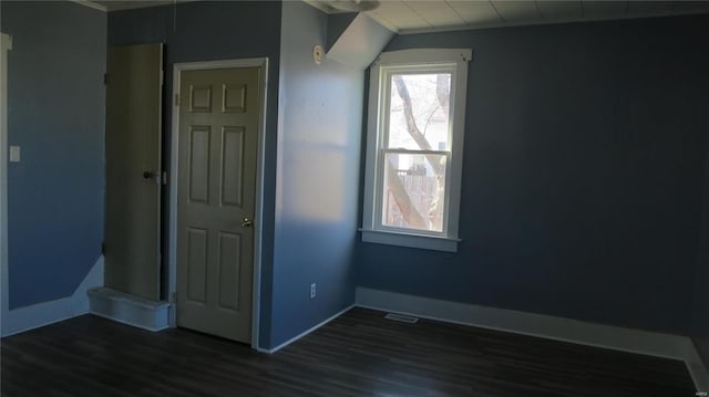 unfurnished bedroom with baseboards, visible vents, and dark wood finished floors