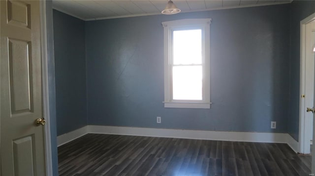 empty room featuring dark wood-style floors, crown molding, and baseboards