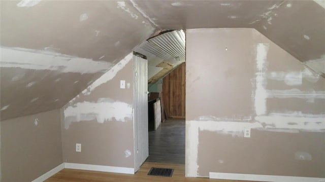 bonus room featuring visible vents, vaulted ceiling, and wood finished floors