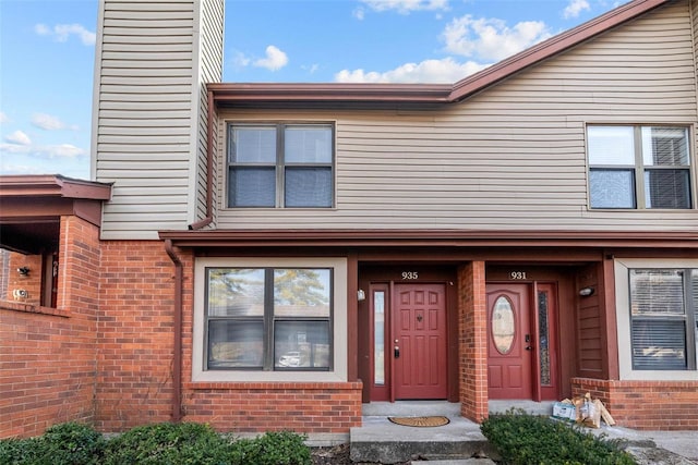 entrance to property featuring brick siding