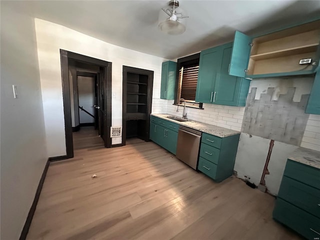 kitchen featuring tasteful backsplash, dishwasher, light wood-style floors, green cabinets, and a sink