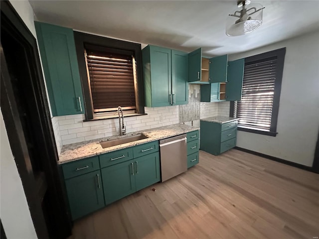 kitchen with light wood-style floors, green cabinets, a sink, and stainless steel dishwasher