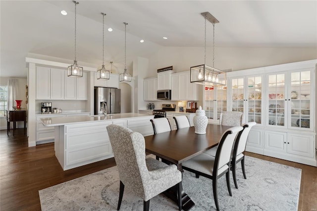 dining room with recessed lighting, high vaulted ceiling, and dark wood-style floors