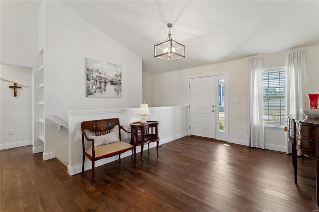 entrance foyer with baseboards, lofted ceiling, an inviting chandelier, and wood finished floors