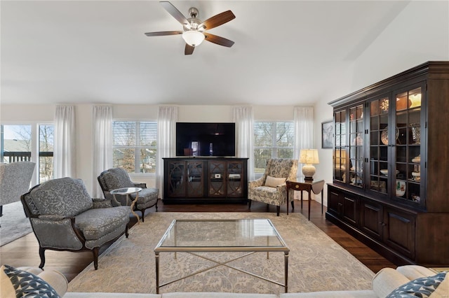 living area with plenty of natural light, ceiling fan, and dark wood-style flooring