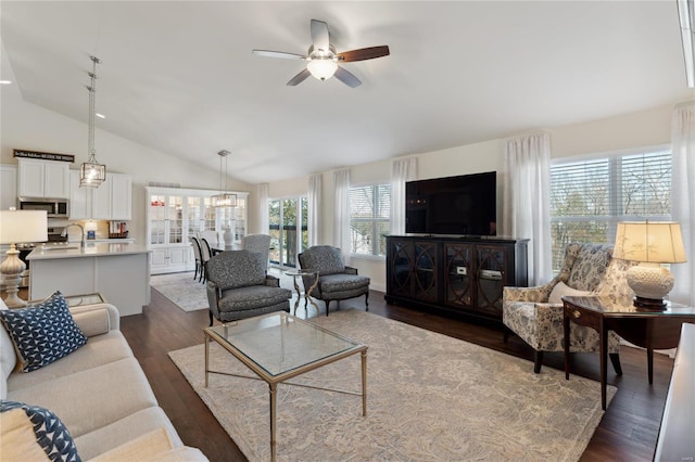 living area featuring dark wood-style floors, high vaulted ceiling, and ceiling fan