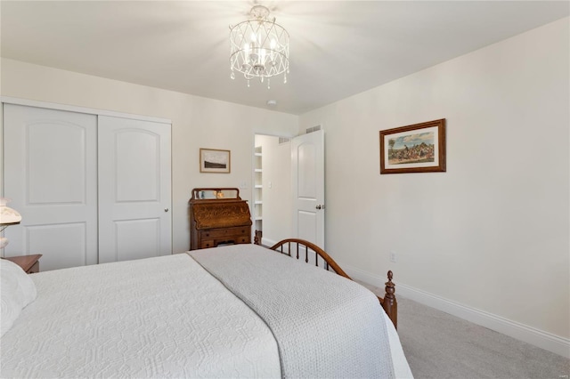 carpeted bedroom with an inviting chandelier, baseboards, and a closet