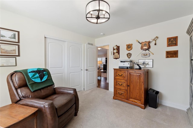 sitting room featuring visible vents, baseboards, a chandelier, and light carpet