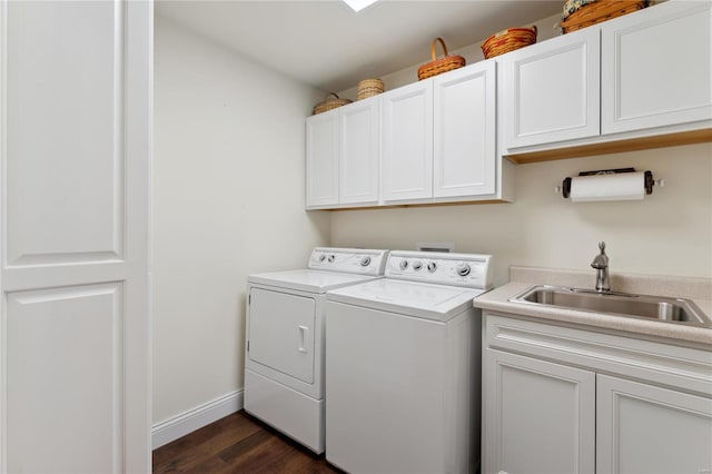 laundry area featuring independent washer and dryer, a sink, dark wood-style floors, cabinet space, and baseboards