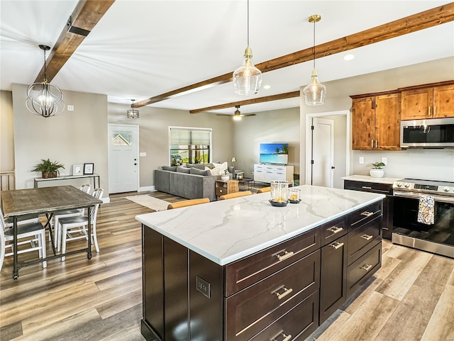 kitchen featuring a kitchen island, appliances with stainless steel finishes, beamed ceiling, light wood-style floors, and pendant lighting