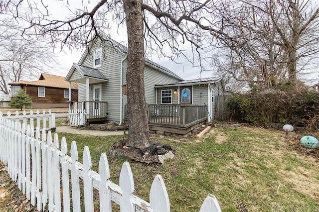 view of side of home with a deck, metal roof, and fence private yard