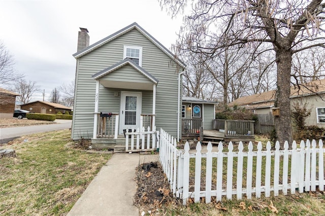 view of front of house with a fenced front yard, a chimney, and a deck