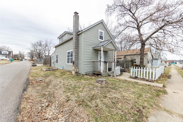 exterior space featuring a chimney and fence