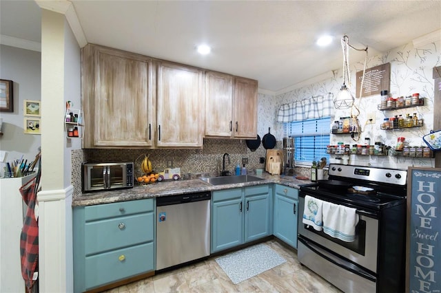 kitchen featuring tasteful backsplash, appliances with stainless steel finishes, a sink, and ornamental molding